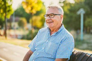 older man sitting on bench outside memory care nursing homes fl