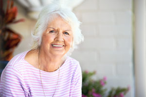 senior woman sitting outside of Independent Senior Living homes in florida